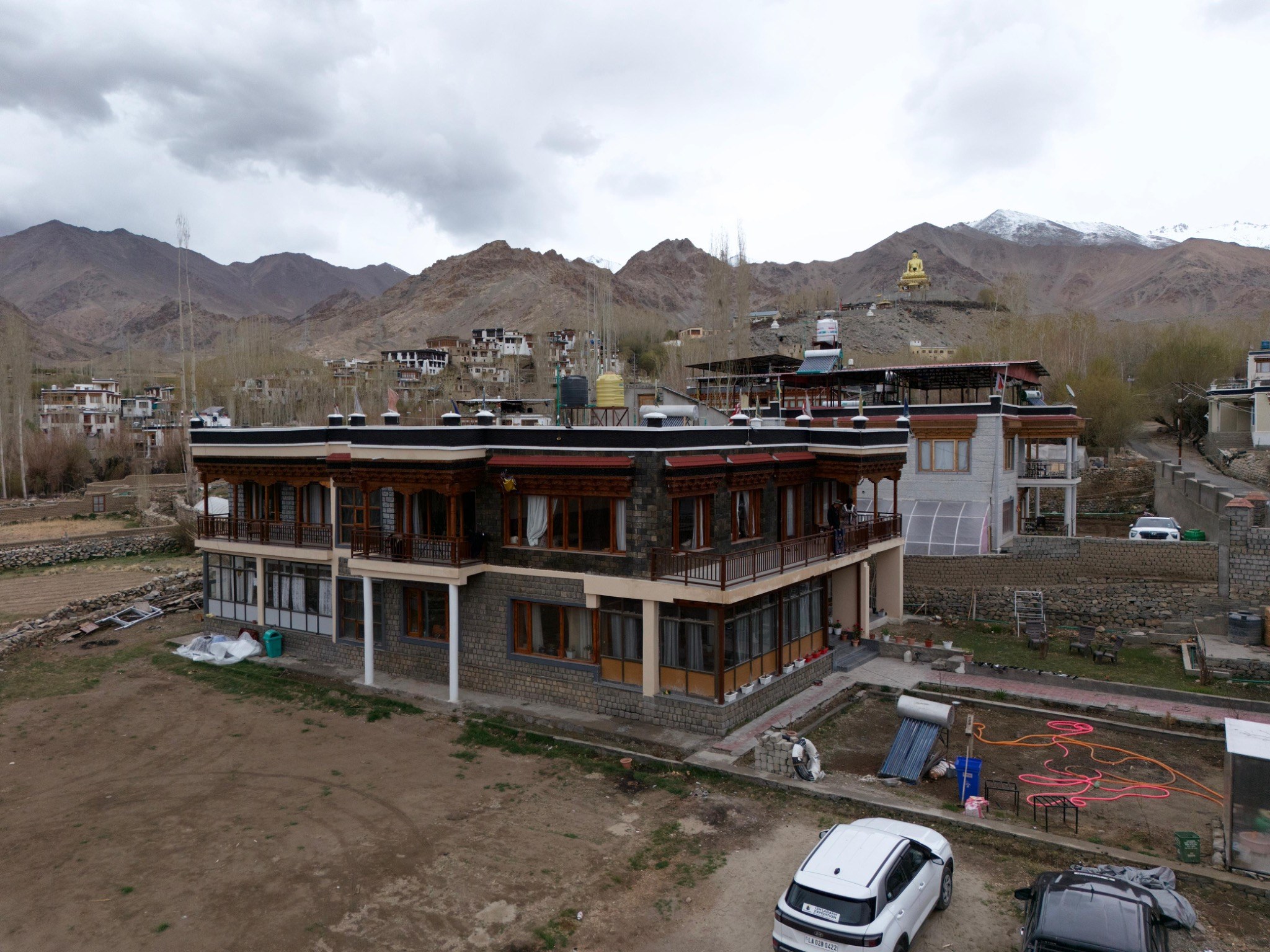 Aerial view of Chos Residency with mountains behind it